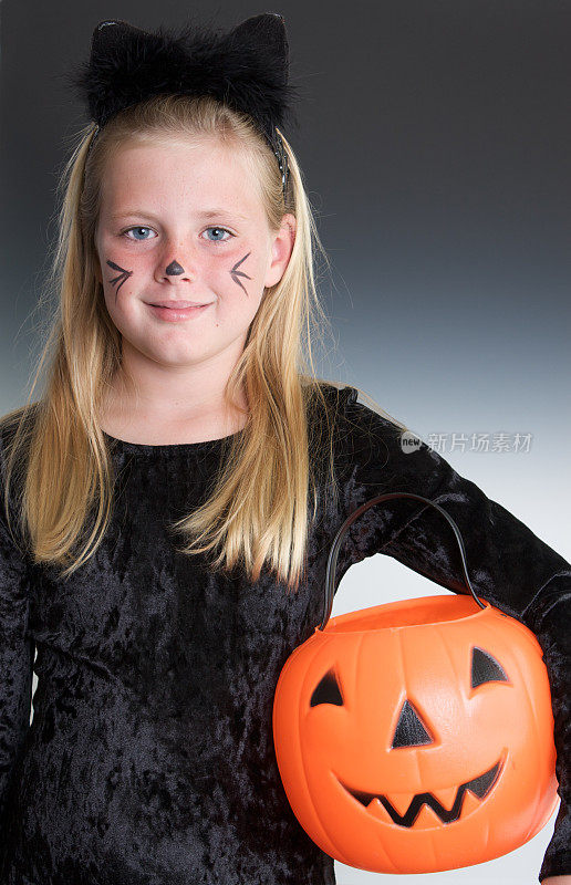 可爱的女孩在万圣节的猫服装Trick or Treating